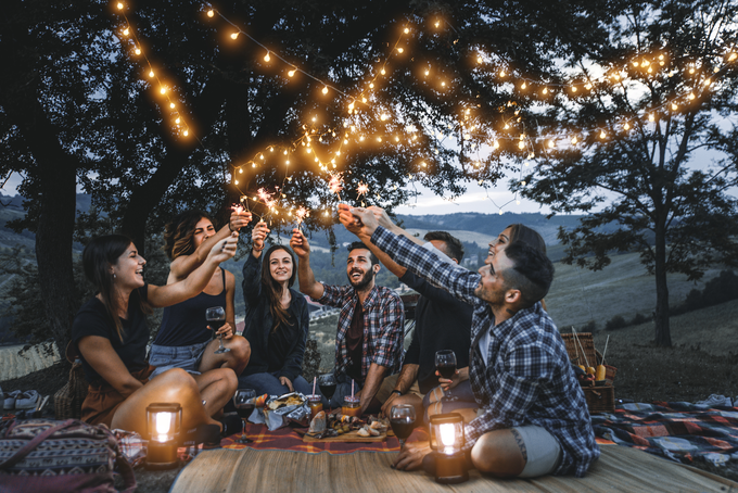 A photo of a group of people celebrating at an evening picnic.